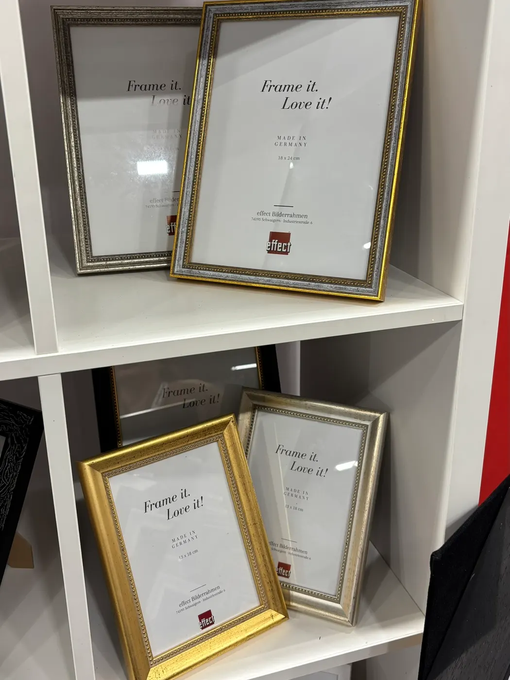 Verzierte Bilderrahmen in Gold und Silber im Regal unseres Messestands