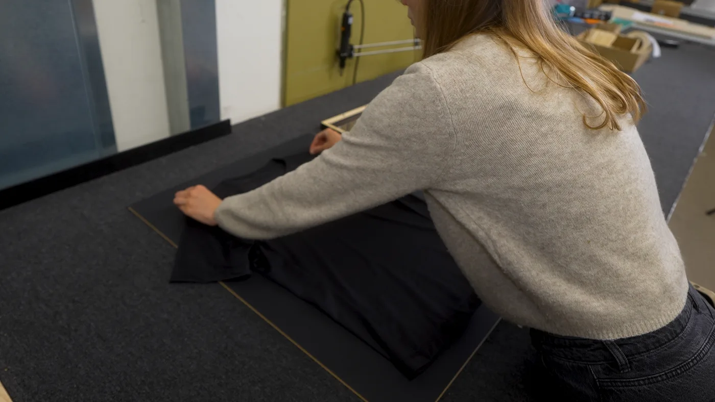 Das Trikot wird mittig auf die Rückwand des Objektrahmens gelegt