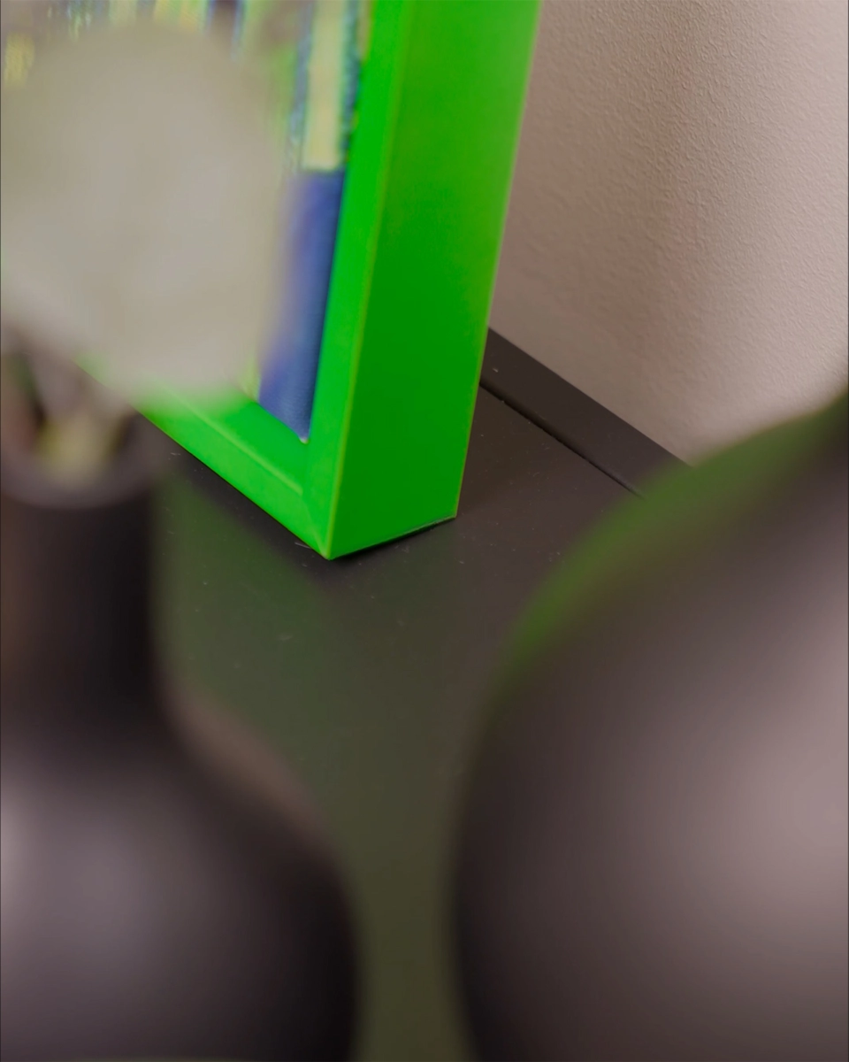 Detailaufnahme der Ecke des Schattenfugenrahmens Jill in leuchtendem Neon-Grün für Leinwandbilder in wohnlichem Ambiente